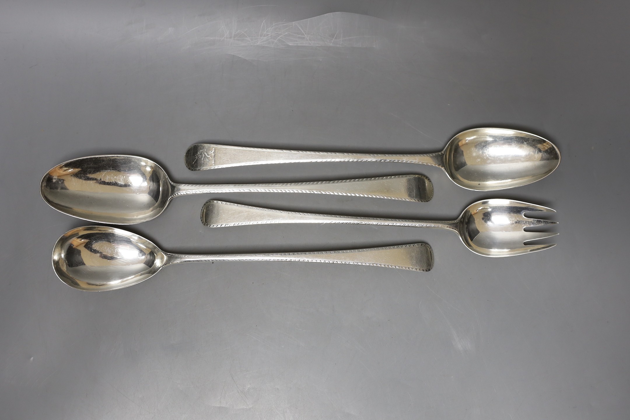 Two George III silver Old English pattern feather edge basting spoons and a pair of similar servers, various makers and dates, marks rubbed, approx. 28.5cm, 11.5oz.